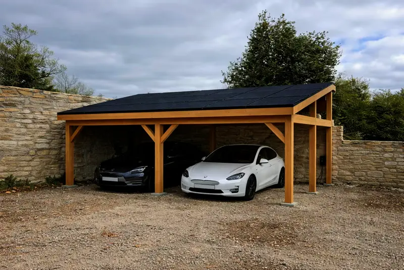 Carport bois, couverture photovoltaïque, le long d’un mur en pierre