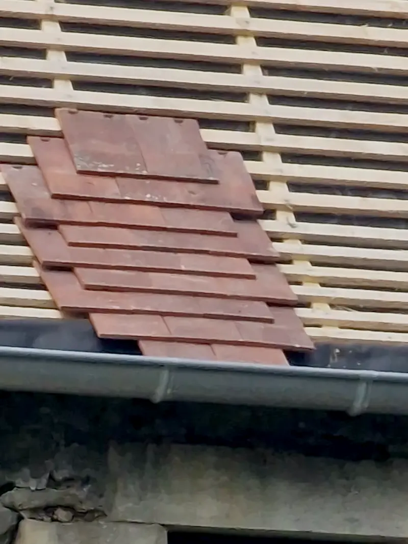 Détail de la couverture, tuiles plates posées sur liteaux de bois neufs au-dessus de la gouttière