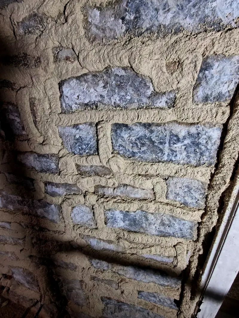Détail d’un mur en pierre rejointoyé, mortier beurré autour de chaque pierre