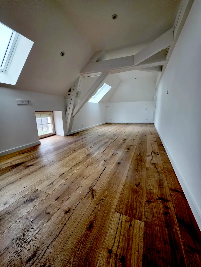 Combles aménagés, charpente conservée et rabotée, velux, parquet massif posé jusque sous les rampants