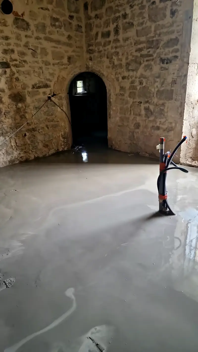 Ragréage coulé en cave voûtée, lance de pompe en place
