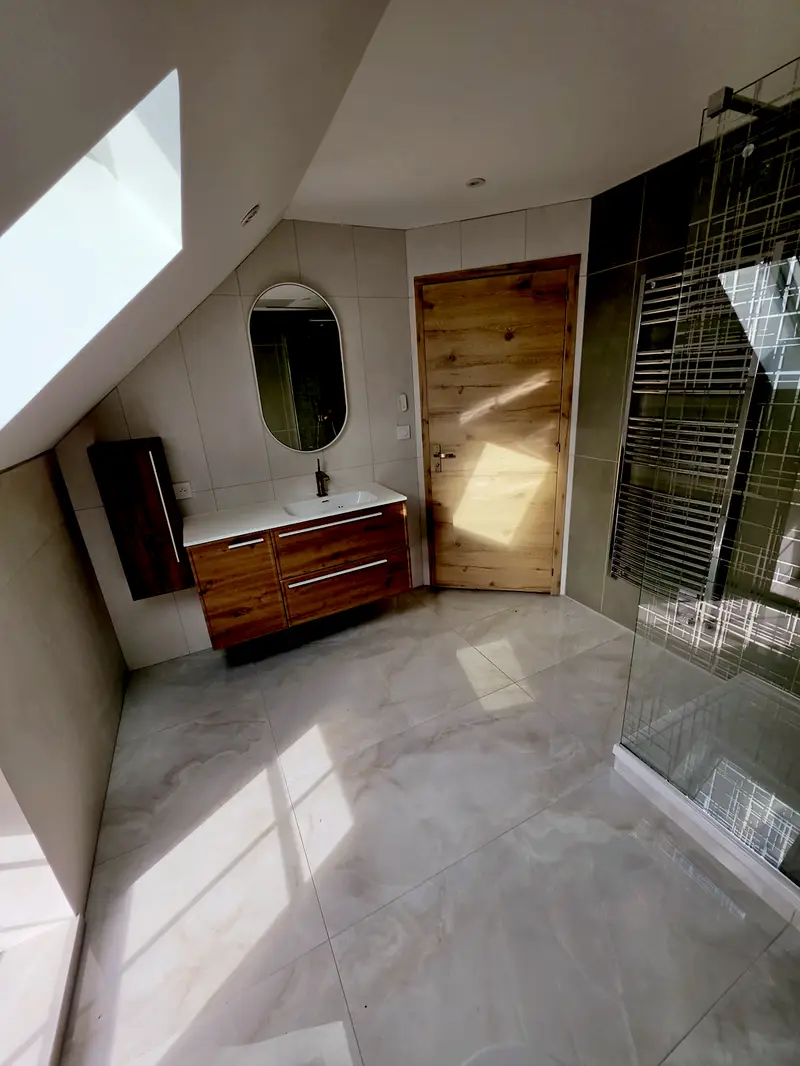 Salle de bains sous rampant livrée, meuble vasque suspendu, paroi vitrée et sèche-serviettes