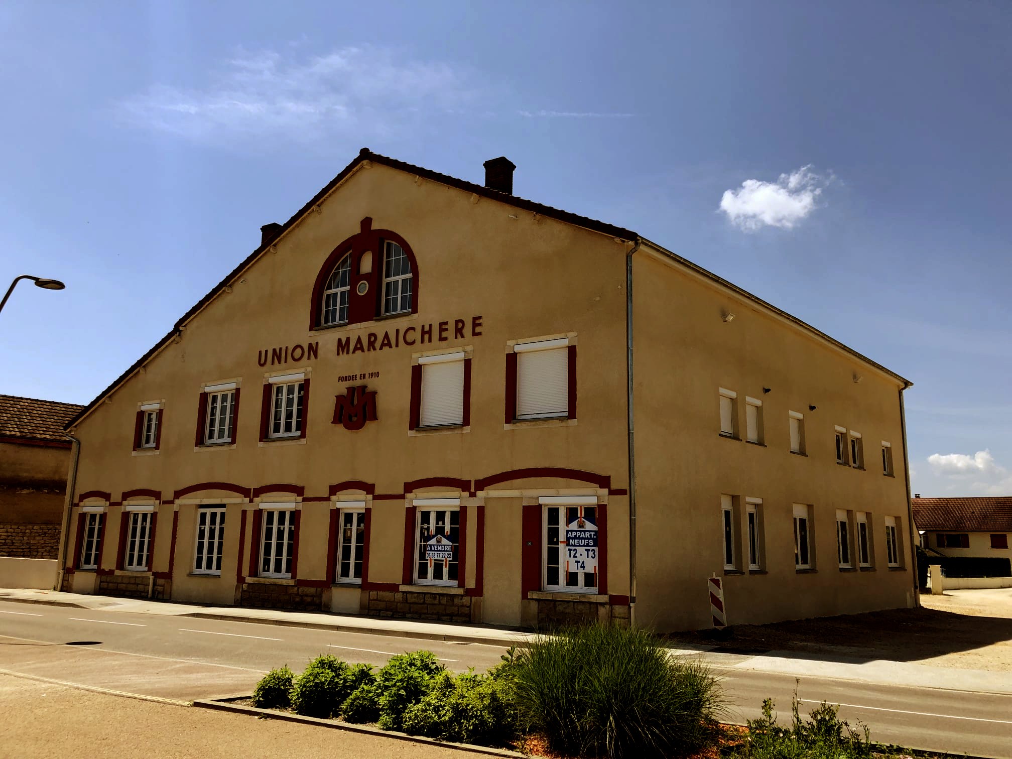 L’ancienne coopérative Union Maraîchère livrée en logements, enduit repris, encadrements et inscription en rouge au fronton